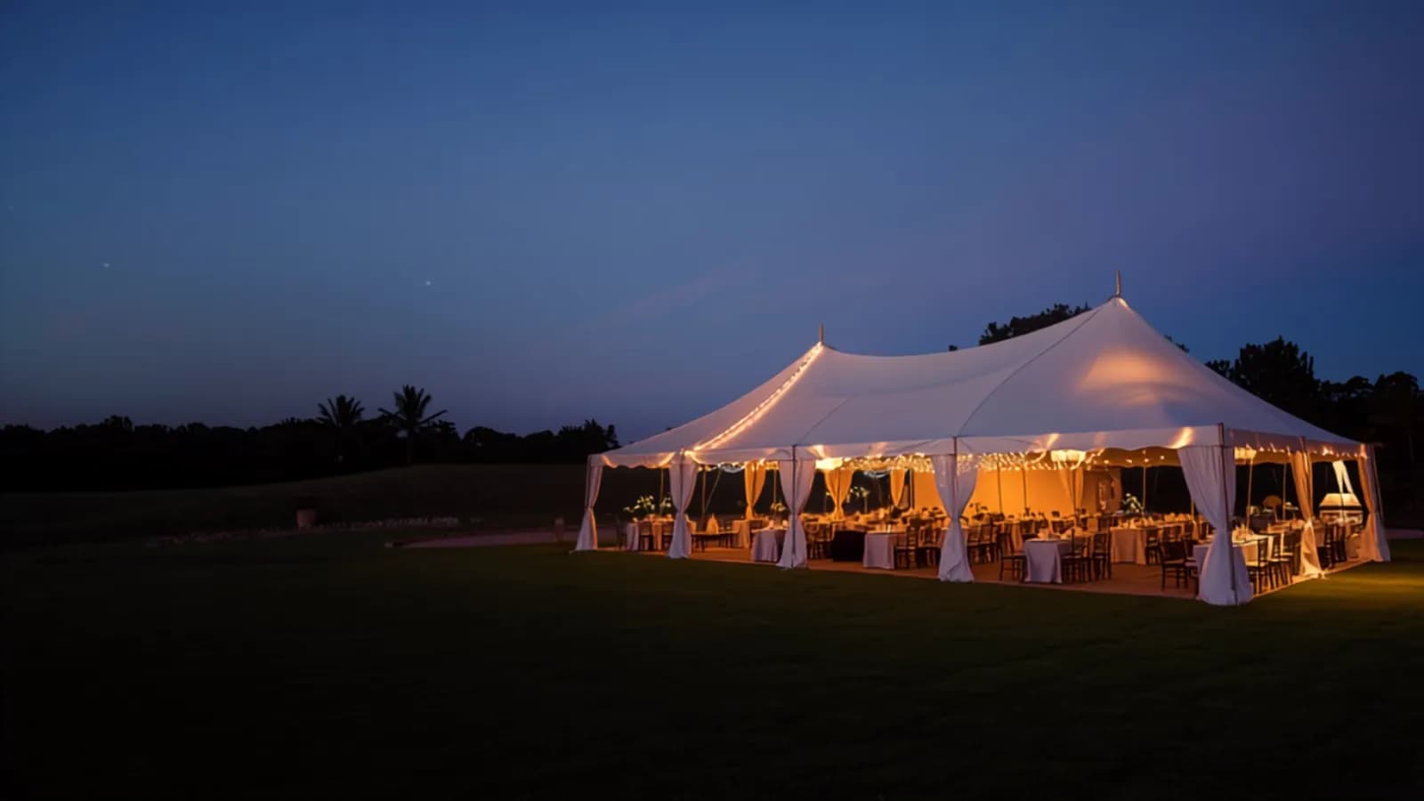 A glowing white event tent at dusk